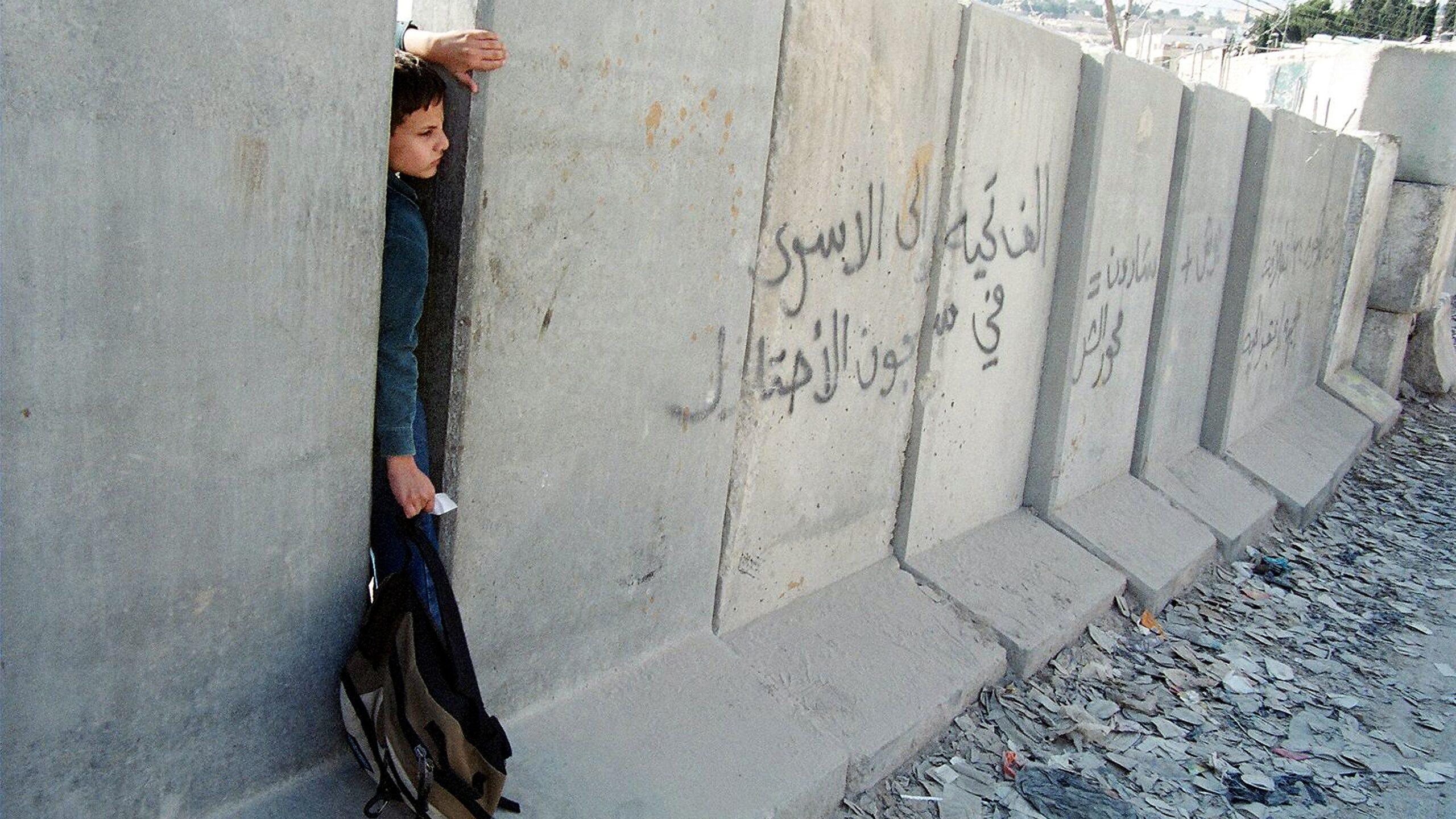 Palestinian schoolboy at separation wall Abu Dis